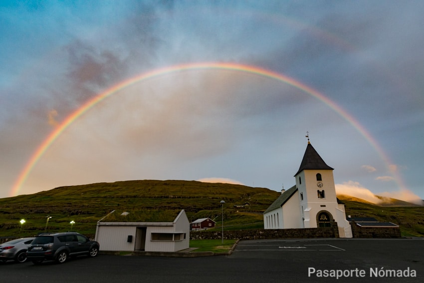 atardecer con arcoiris sobre la iglesia de eidi en las islas feroe